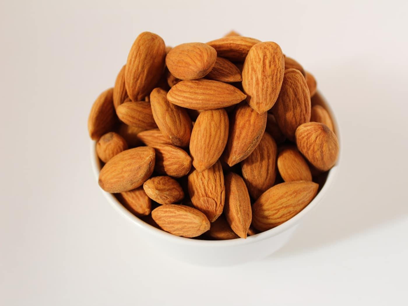 Whole almonds in a plain white bowl